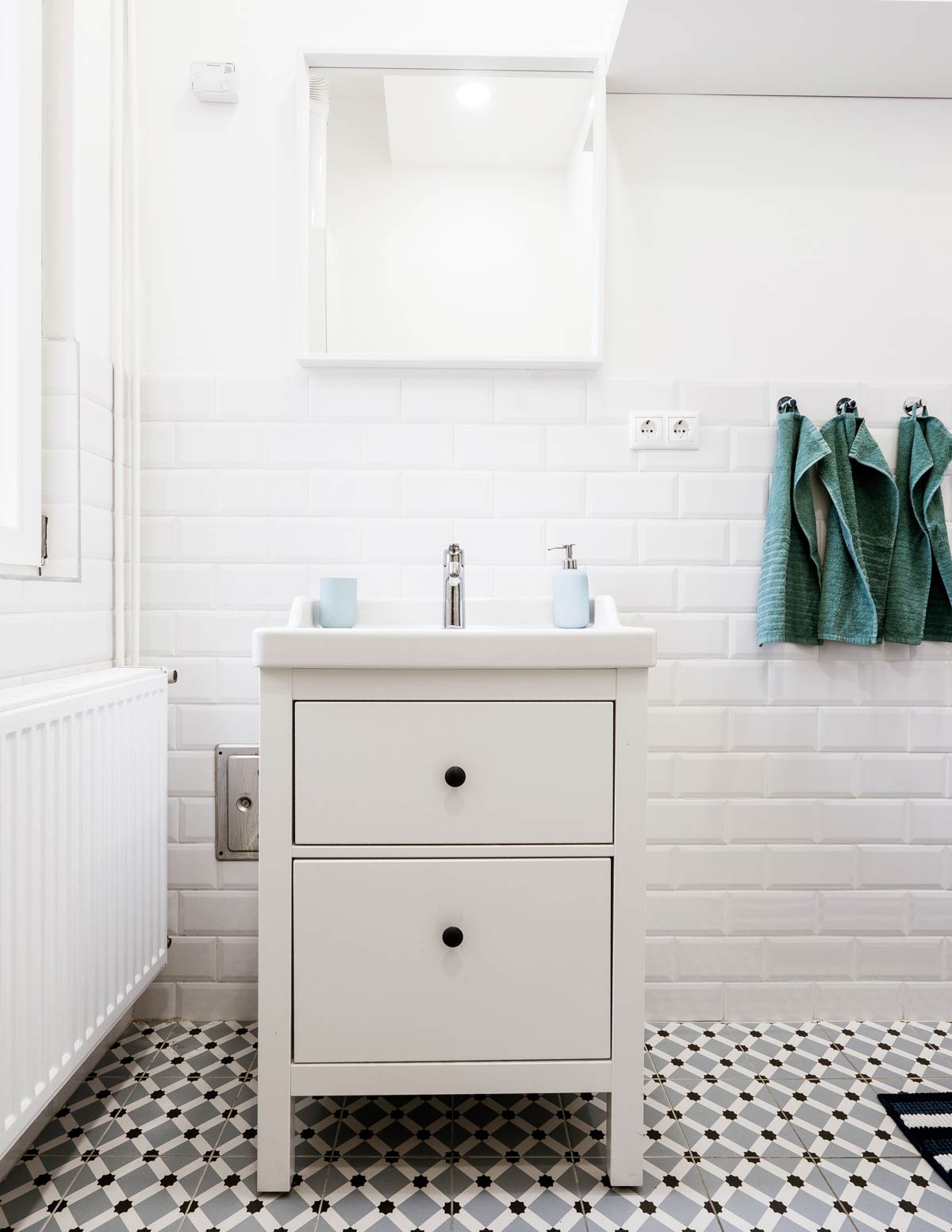 Biała łazienka z podłogą w geometryczny, biało-czarny wzór