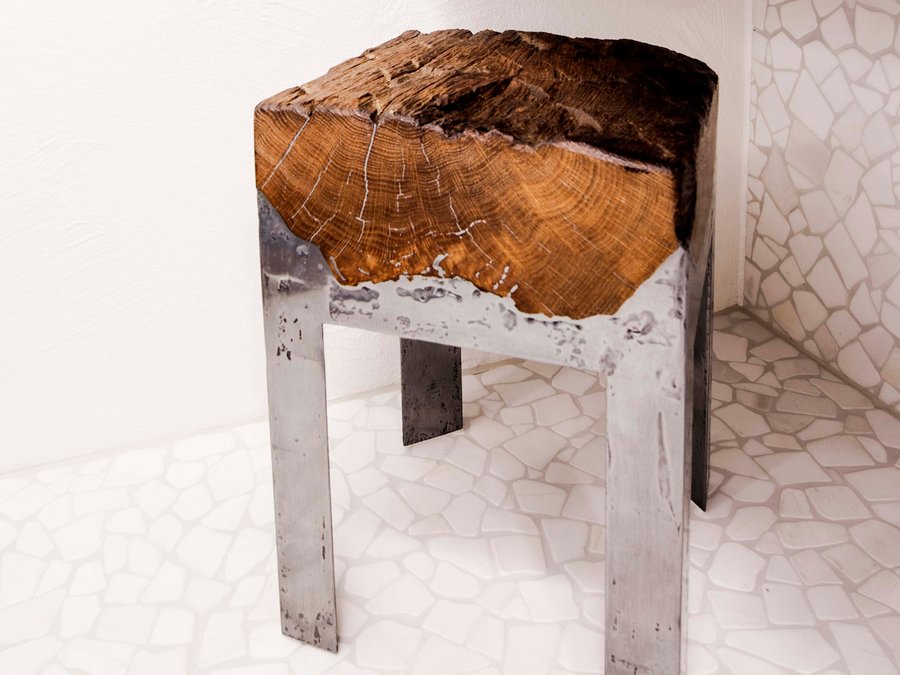 Drewniany stołek z nogami pokrytymi płynnym metalem